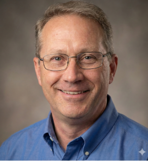 Professional headshot of Dave, middle-aged man with glasses wearing blue collared shirt, smiling at camera